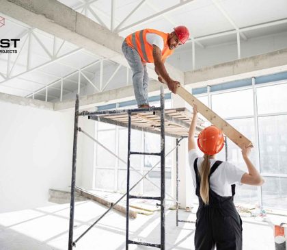 Two construction workers complete interior fitout works inside a commercial space