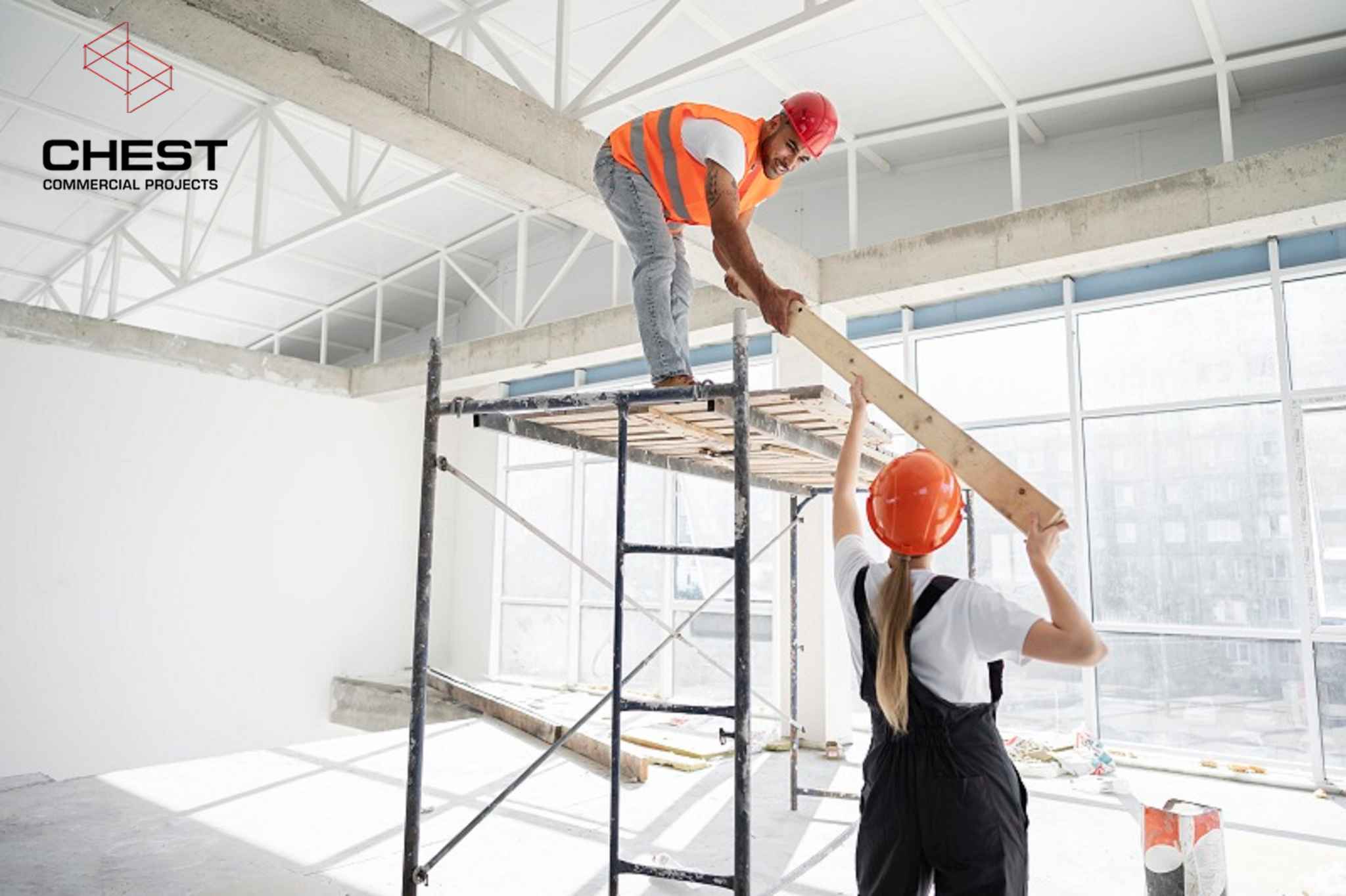 Two construction workers complete interior fitout works inside a commercial space
