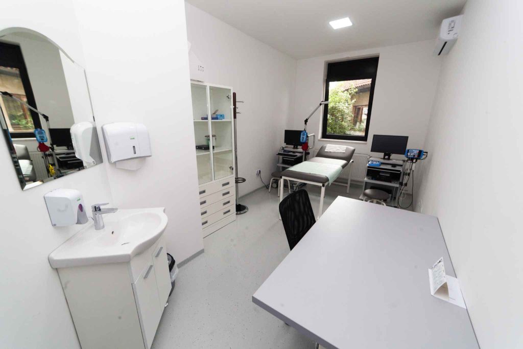 Compact medical treatment room with examination bed, sink, storage and clinical equipment, showing efficient space planning for a Perth healthcare fitout.